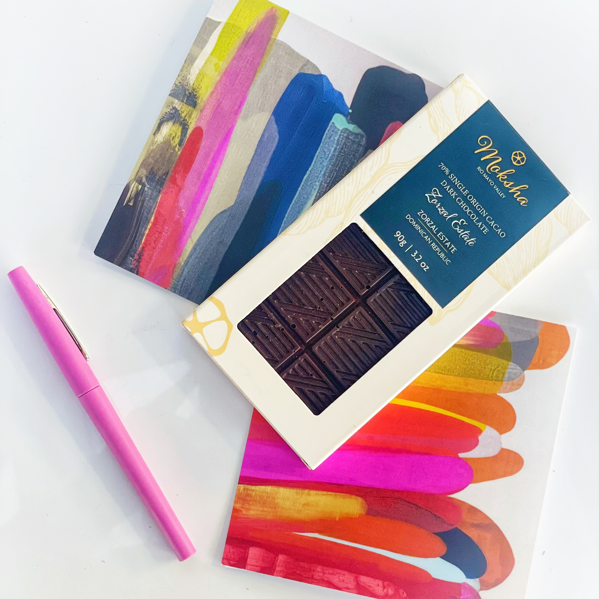 Moksha Zorzal Estate 70% Single Origin Dark Chocolate Bar paired with abstract art greeting cards and pink pen – premium chocolate gift set for birthdays, anniversaries, or thoughtful notes.