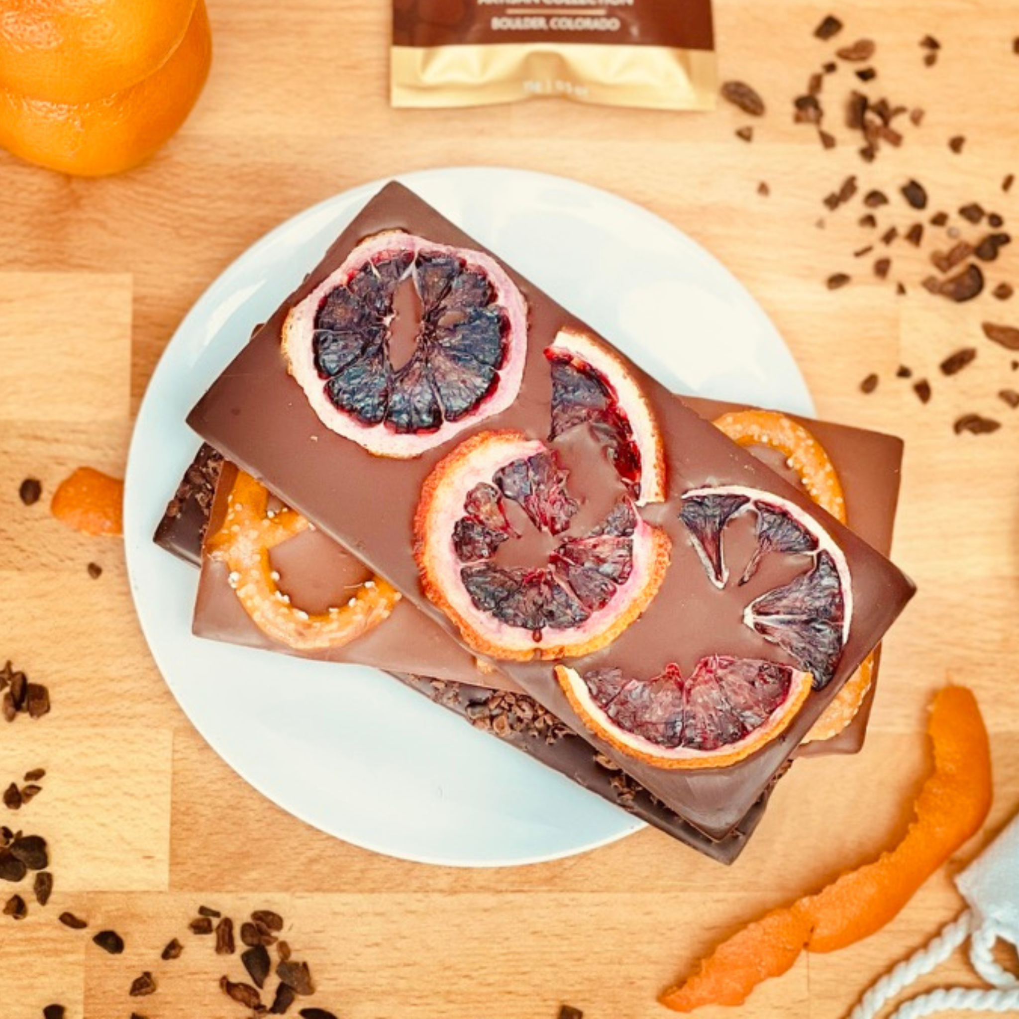 Moksha Chocolate bar with blood orange slices on a wooden surface