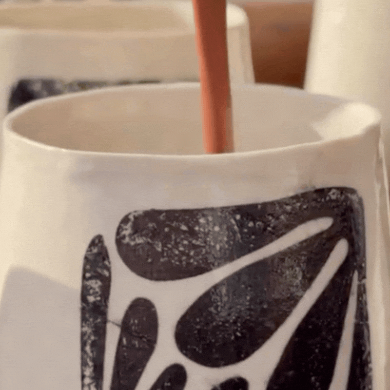 Ceremonial cacao being stirred in a handmade mug during a shared chocolate tasting