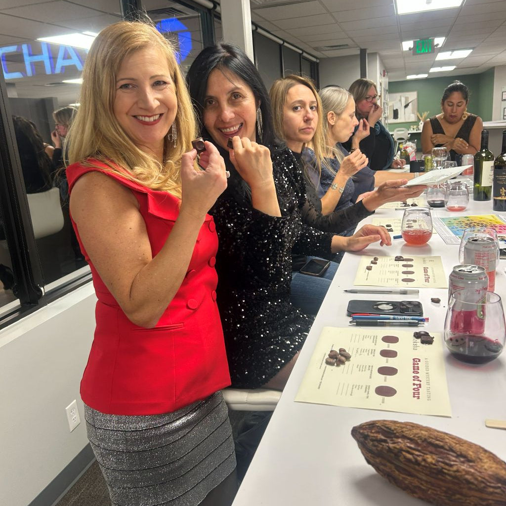 Group of people at a table with a cacao bean display, likely in an office setting.