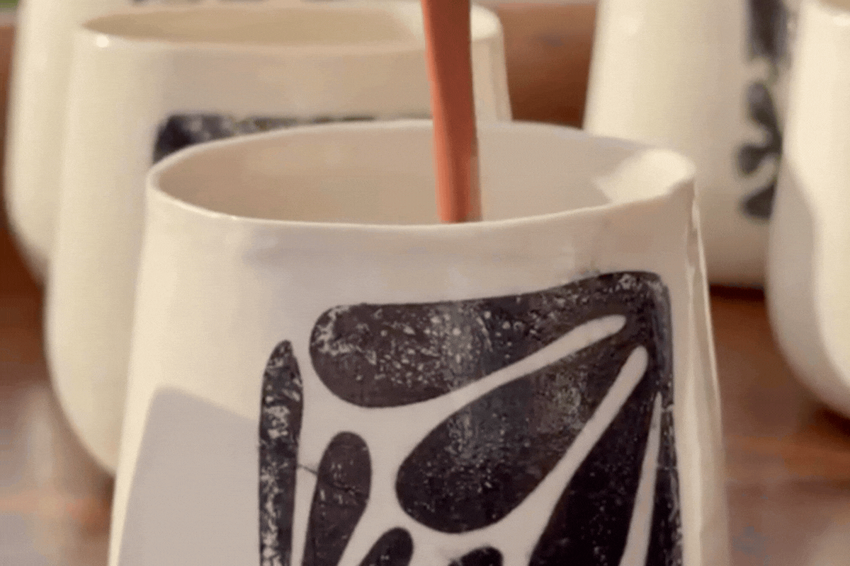 Ceremonial cacao being stirred in a handmade mug during a shared chocolate tasting