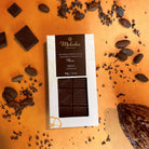 Moksha 65% chocolate bar packaging with cacao beans on an orange background