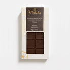 Moksha 65% single origin semisweet chocolate bar from Bejofo, Madagascar, in white packaging with a dark brown label and a window revealing the chocolate bar.