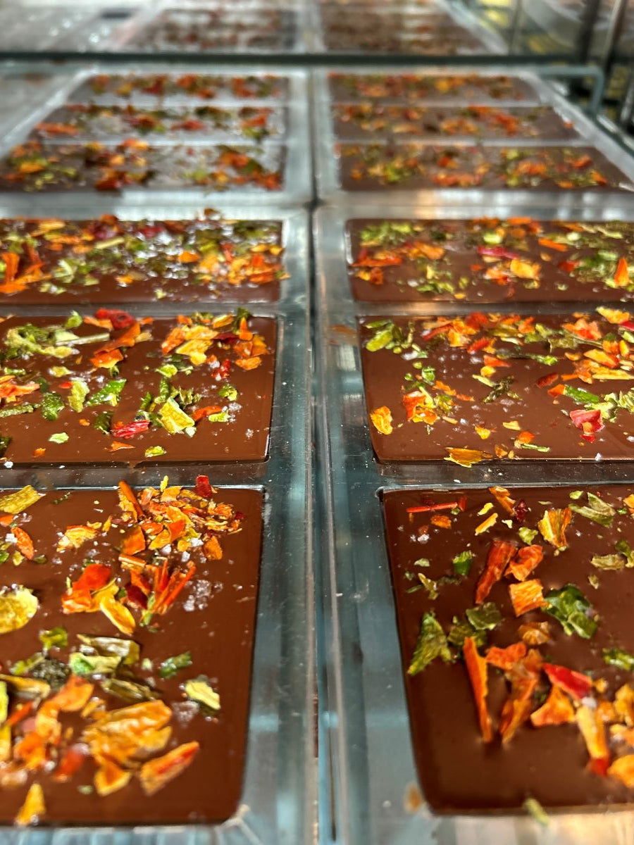 Chocolate bars with pueblo chile toppings getting ready to be packaged.