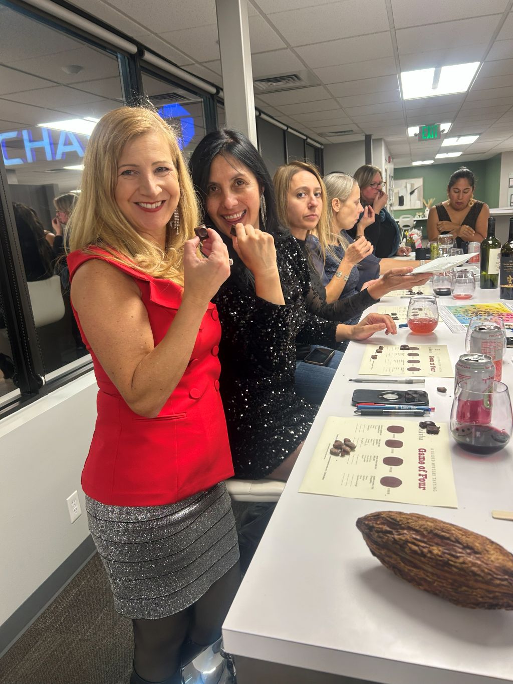 Group of people at a table with a cacao bean display, likely in an office setting.