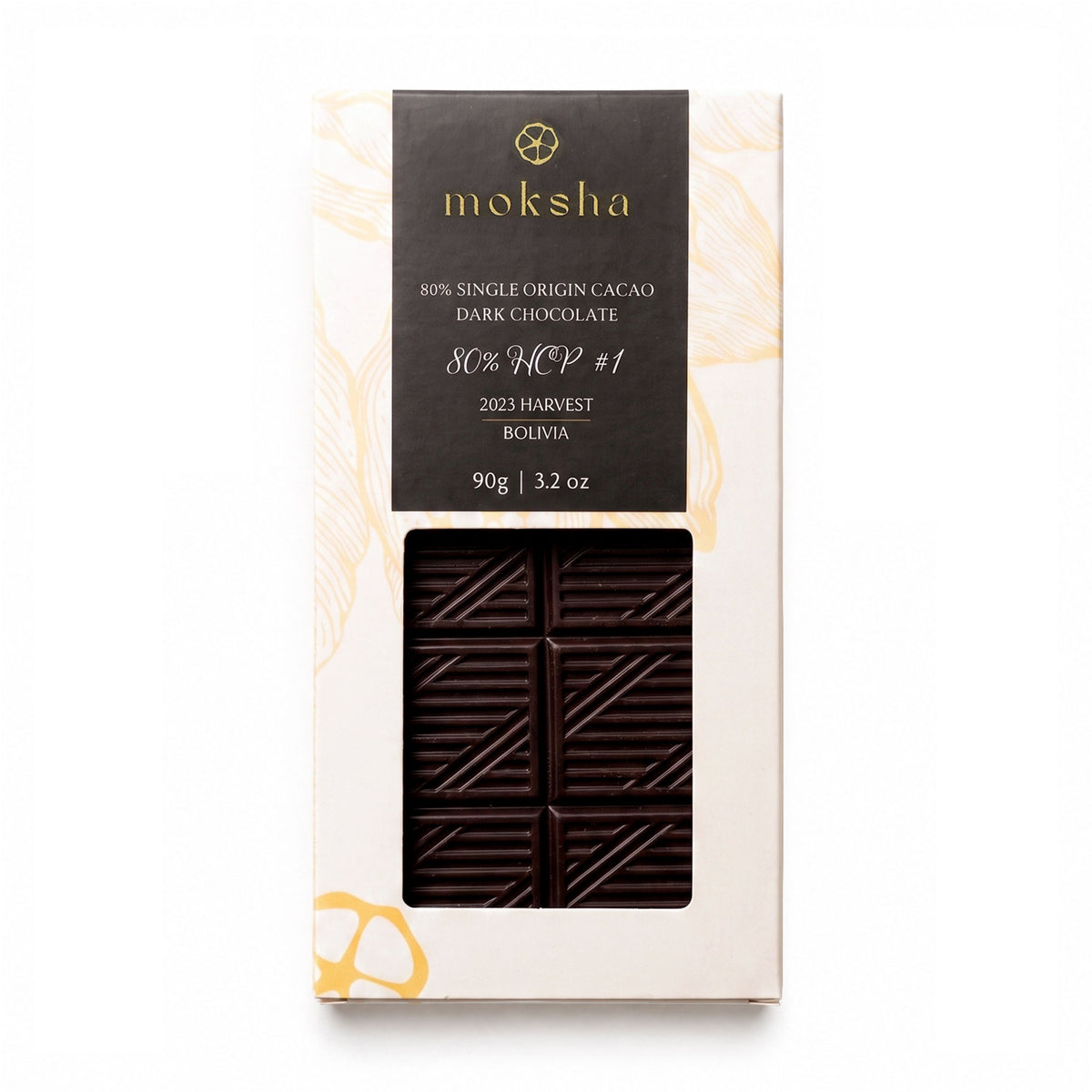 A top-down photograph of a packaged Moksha 80% Single Origin Dark Chocolate bar from the 2023 Bolivia harvest, 90g (3.2 oz), on a plain white background. The packaging features gold botanical leaf patterns and a die-cut window showing the geometric patterned dark chocolate bar inside.