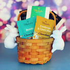 A woven basket filled with Moksha functional mushroom chocolate bars, including Reishi and Cordyceps & Lion’s Mane, flanked by white bunny figures, with a soft, colorful bokeh background.
