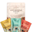 Moksha's mushroom chocolate gift bundle, featuring a large Ceremonial Cacao Paste pouch arranged behind three smaller functional mushroom chocolate packets in yellow, teal, and red on a clean white background.