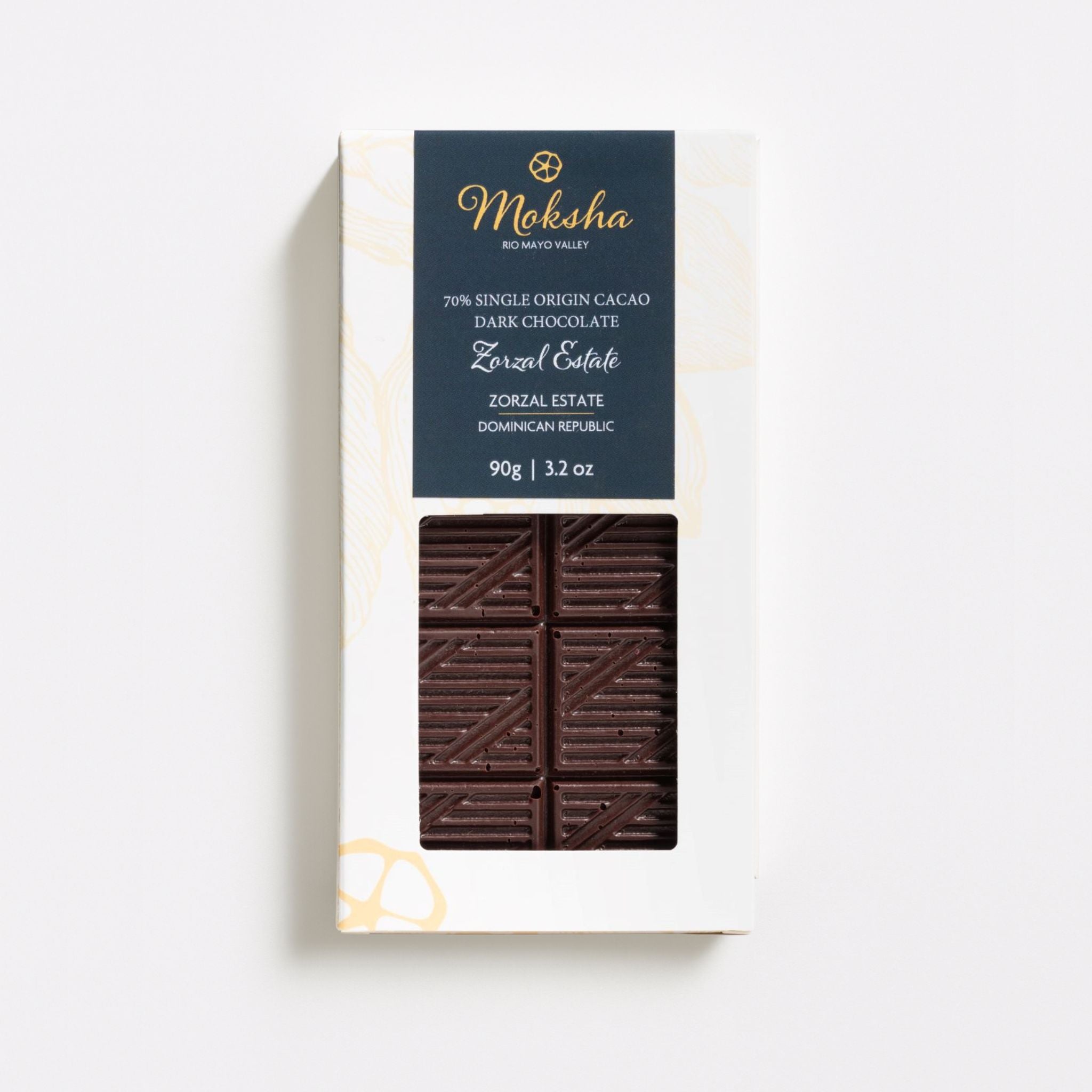 Front view of the Moksha Zorzal Estate 70 percent Single Origin Dark Chocolate Bar in its white and navy packaging, showing the patterned dark chocolate.